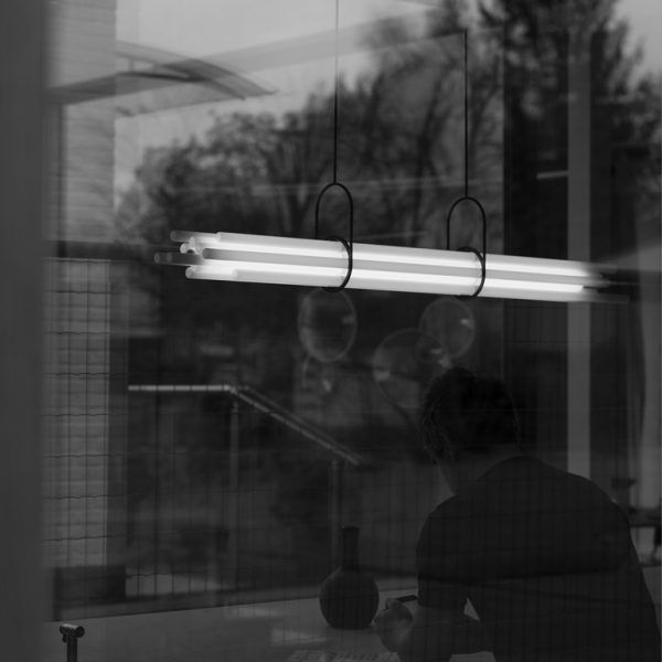 Suspension NL12 de chez DCW Éditions installée dans un intérieur contemporain, lumière indirecte et design architectural.