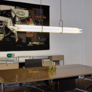 NL12 de chez DCW, suspension lumineuse composée de tubes horizontaux suspendus dans un espace intérieur